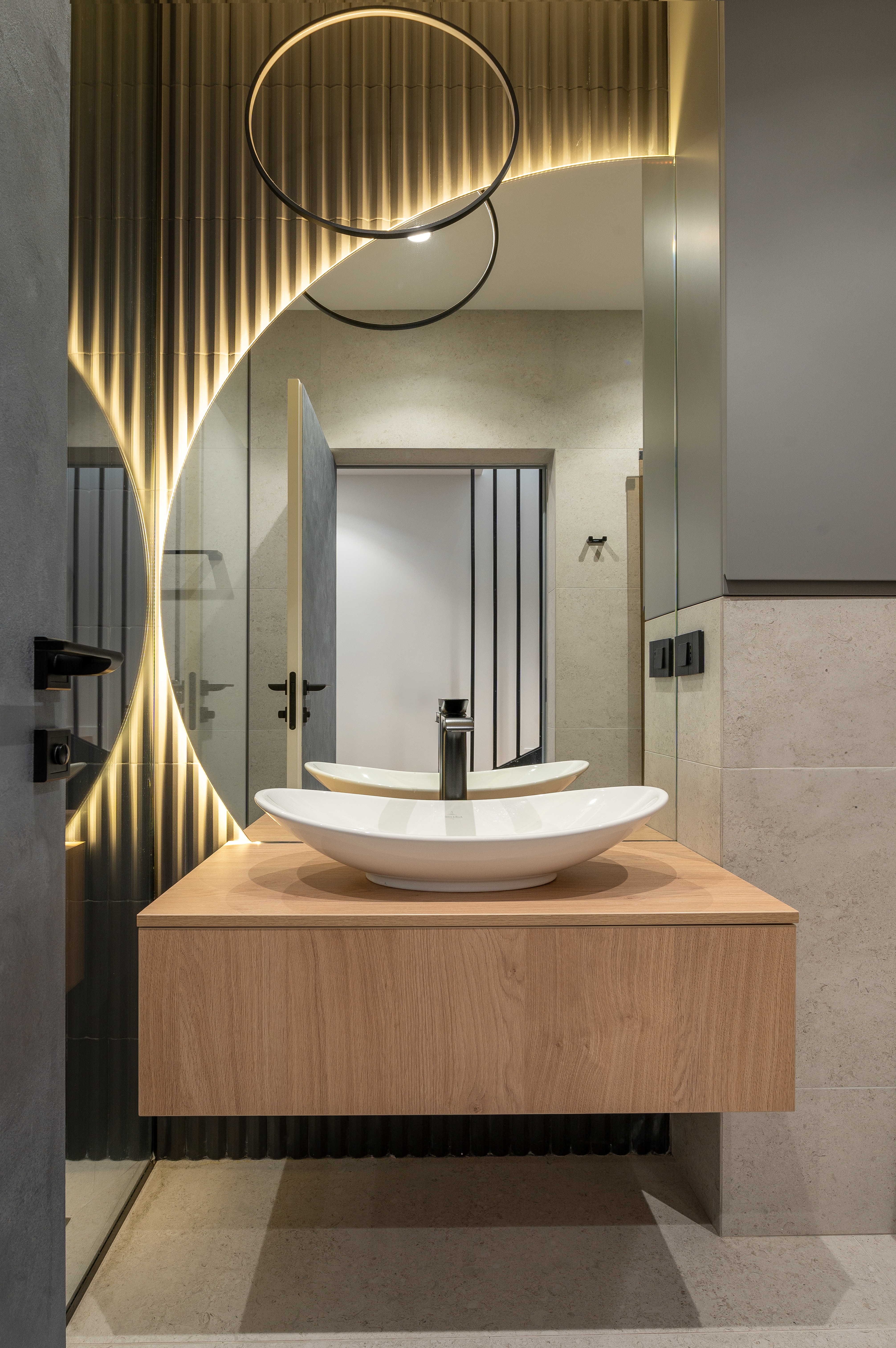 Baie elegantă cu oglindă decorativă în formă de semilună și iluminare LED caldă, mobilier din lemn și accente negre – design MAD architecture&design.