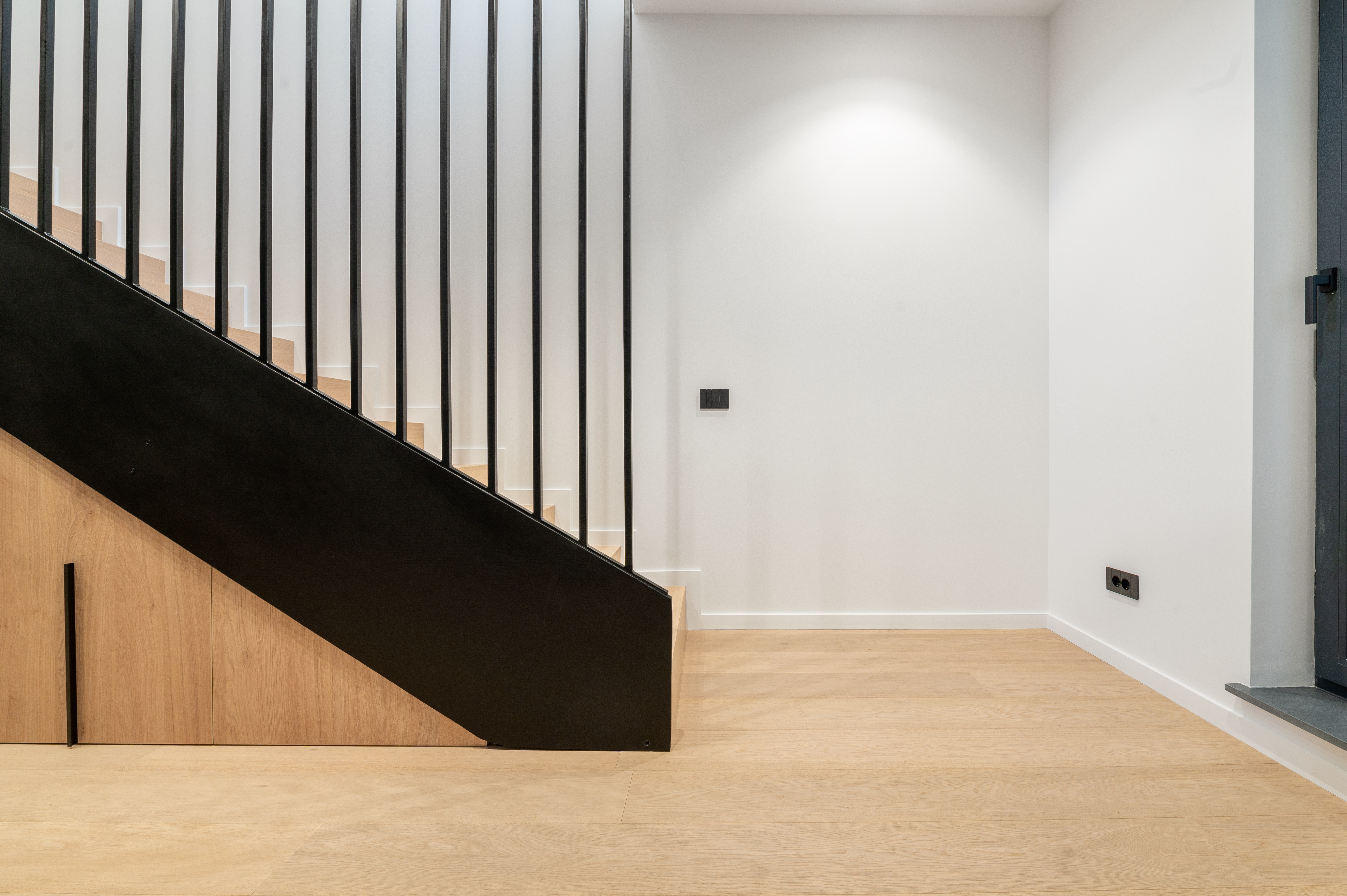 Casa scării cu balustradă metalică neagră, trepte din lemn natural și design geometric minimalist – proiect MAD architecture&design.